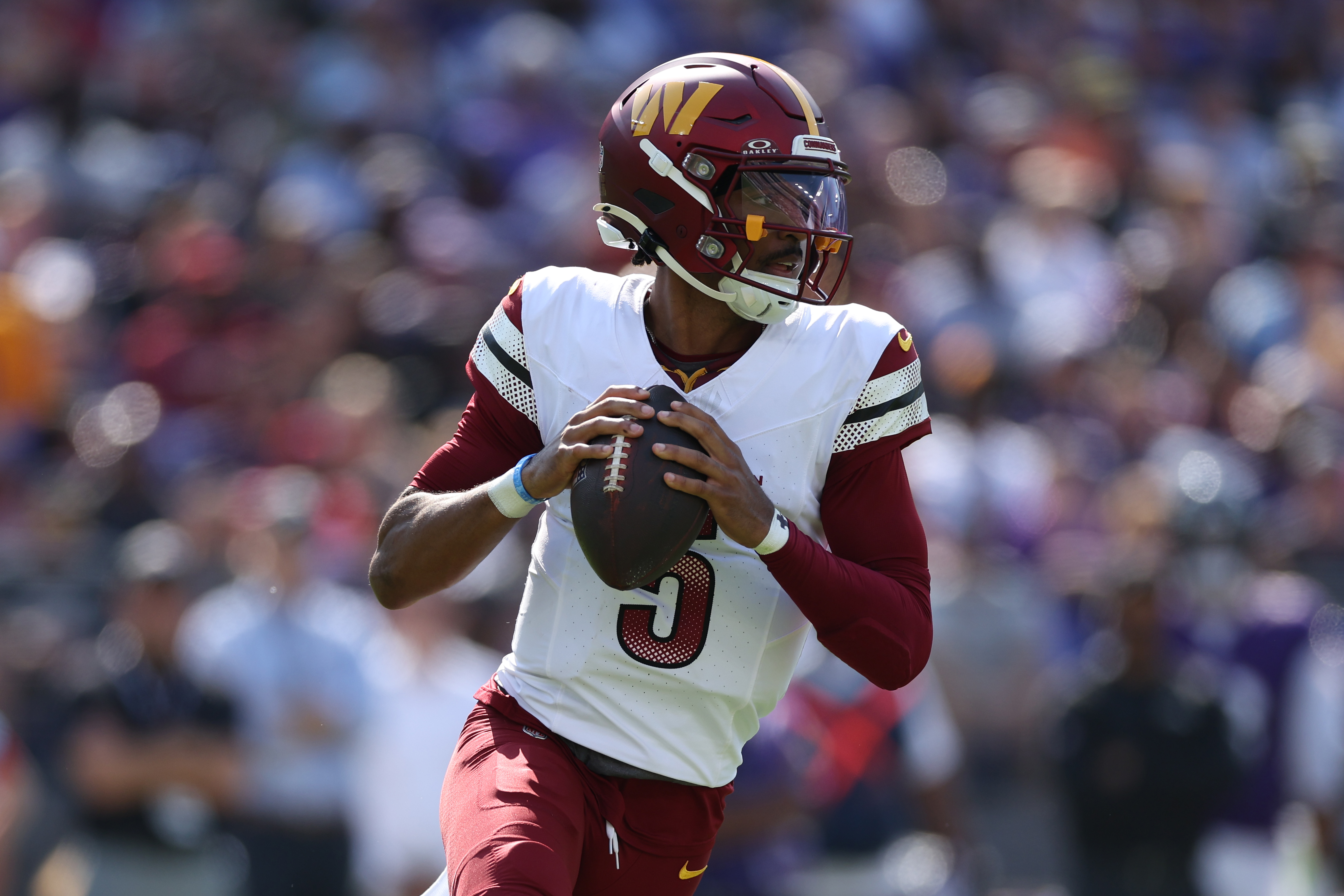 Quarterback Jayden Daniels #5 of the Washington Commanders rushes with the ball against the Baltimore Ravens at M&amp;T Bank Stadium on October 13, 2024 in Baltimore, Maryland.